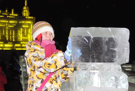 A visitor poses for photos in the Ice and Snow World in Harbin, capital of northeast China's Heilongjiang Province, on Dec. 23, 2008. The annual ice and snow world in Harbin began a test run on Tuesday. [Xinhua]