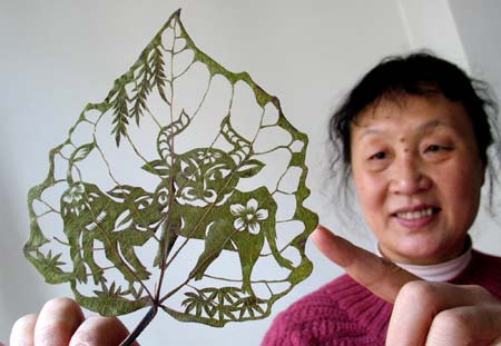 Citizen Du Wanli shows a handmade leaf-carving artwork featuring the patterns of ox in Jinan, capital of east China's Shandong Province, Dec. 23, 2008, to welcome the forthcoming year of ox in Chinese lunar calendar. [Xinhua] 