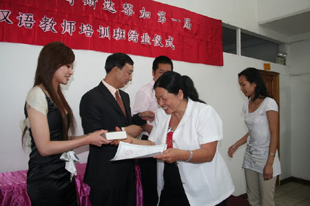 Sheng Xiwen (L2), educational commissioner of Chinese Embassy to Costa Rica, and Gao Minjun (L1), director of a Chinese language school in Costa Rica, award certificates and souvenirs to students in San Jose, Costa Rica, on December 22, 2008. A celebration is held on Tuesday after the first Chinese language teachers training class completed its courses in Costa Rica.