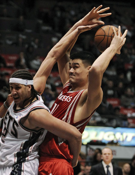 New Jersey Nets center Josh Boone (L) fouls Houston Rockets center Yao Ming in the second half of their NBA basketball game in East Rutherford, New Jersey December 22, 2008. 