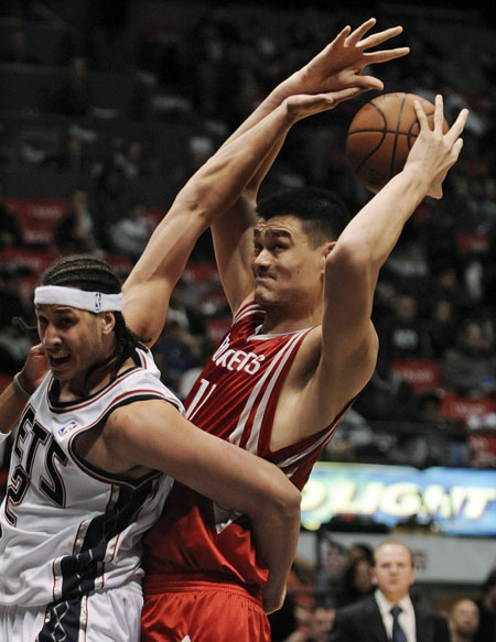 New Jersey Nets center Josh Boone (L) fouls Houston Rockets center Yao Ming in the second half of their NBA basketball game in East Rutherford, New Jersey December 22, 2008.