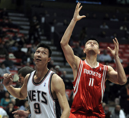 New Jersey Nets forward Yi Jianlian reacts as Houston Rockets center Yao Ming (R) reaches for the rebound in the first quarter of their NBA basketball game in East Rutherford, New Jersey December 22, 2008.