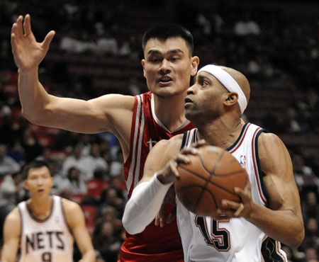 New Jersey Nets guard Vince Carter (15) tries to drive around Houston Rockets center Yao Ming (L) in the first quarter of their NBA basketball game in East Rutherford, New Jersey December 22, 2008.