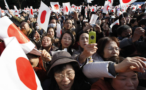 Well-wishers take photographs and wave Japan's national flags during Emperor Akihito's 75th birthday at the Imperial Palace in Tokyo December 23, 2008.