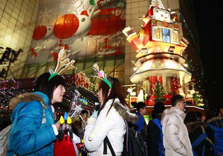 People gather at a square that is illuminated by Christmas lights in downtown Shanghai Dec. 24, 2008. 