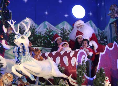 A man dressed as Santa Claus poses with women and children in front of the Monument to the Revolution as part of Christmas celebrations in Mexico City Dec. 23, 2008. 