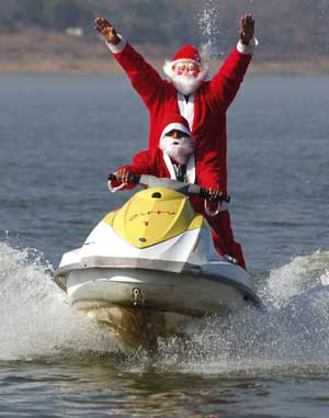 People dressed up as Santa Claus enjoy a water scooter ride in a lake ahead of Christmas celebrations in the central Indian city of Bhopal Dec. 23, 2008.