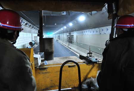 Construction workers drive a bulldozer in a newly completed tunnel under the Yangtze river in Wuhan, capital of central China's Hubei Province, Dec. 24, 2008. The 3.6-km-long tunnel, scheduled to open on Dec. 28, is China's first road tunnel under the Yangtze river.