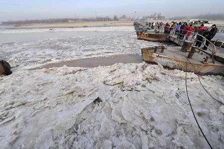 People watch ice and slush floating on the Yellow River at the Jinan section in Jinan, east China's Shandong Province December 23, 2008. [Xinhua]