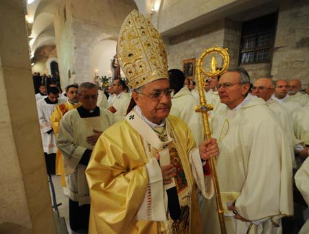 Palestinian President Mahmoud Abbas (L) hugs Latin Patriarch of Jerusalem Fouad Twal after a midnight mass in St. Catherine's Catholic Church which connects with the Church of Nativity in the West Bank city of Bethlehem December 25, 2008. [Yin Bogu/Xinhua]