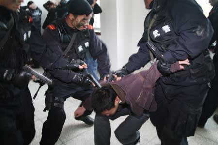 Members of local special police capture an impersonative suspect during an anti-hostage-taking drill in Guiyang, capital of southwest China's Guizhou Province, Dec. 25, 2008. [Xinhua]