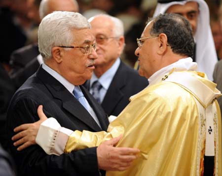 Palestinian President Mahmoud Abbas (L) hugs Latin Patriarch of Jerusalem Fouad Twal after a midnight mass in St. Catherine's Catholic Church which connects with the Church of Nativity in the West Bank city of Bethlehem December 25, 2008. [Yin Bogu/Xinhua]