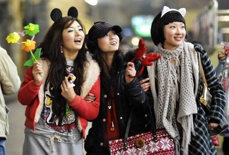 Three girls wearing cartoon head tuingas play on a street in Yichang, central China's Hubei Province, Dec. 24, 2008, the day of the Christmas eve.[Huang Xiang/Xinhua]