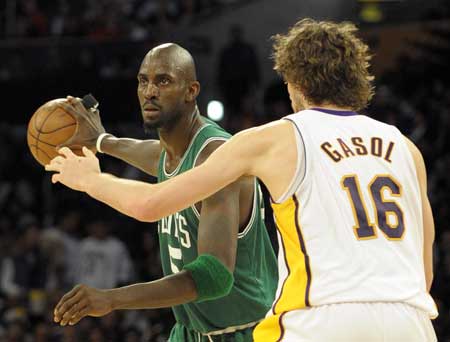 Kevin Garnett (L) of Boston Celtics tries to pass the ball during the NBA games against Los Angeles Lakers in Los Angeles December 25, 2008.