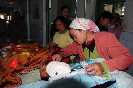 A woman nurses her injured fellow villager in Ruili of Southwest China's Yunnan Province aftert three earthquakes measuring 4.9, 4.3 and 4.0 on the Richter scale hit Southwest China on December 26, 2008. The earthquakes have left 19 wounded and 49,789 affected. [Xinhua]