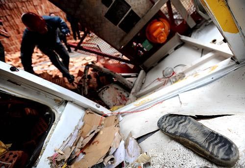 An expert examines the collapsed construction lift at the site of the accident, Changsha City, Central China's Hunan Province, December 27, 2008. [Xinhua]