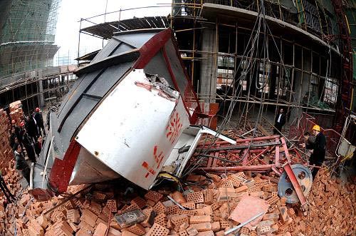 Experts examine the collapsed construction lift at the site of the accident, Changsha City, Central China's Hunan Province, December 27, 2008. [Xinhua]