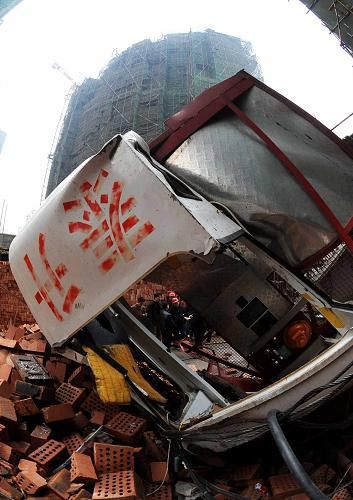 Experts examine the collapsed construction lift at the site of the accident, Changsha City, Central China's Hunan Province, December 27, 2008. [Xinhua]