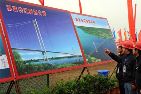 Builders look at an effect picture of the No.4 Cross Yangtze River Bridge as the construction of the bridge started in Nanjing, capital of east China's Jiangsu Province, Dec. 28, 2008. [Sun Can/Xinhua]