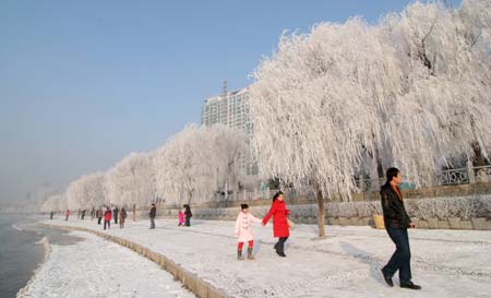 Tourists view the rime scenery by the Songhua River in Jilin city, northeast China's Jilin Province, Dec. 28, 2008. A beautiful rime scenery appeared on the both banks of the Songhua River recently due to the sudden temperture drop in this region, attractings swarms of tourists. [Xinhua]