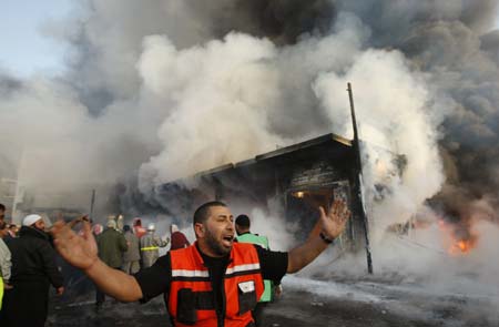 Palestinian fire fighter shouts in front of a burning building following an Israel air strike in Gaza Strip December 28, 2008. Israel launched air strikes on Gaza for a second successive day on Sunday, piling pressure on Hamas after 285 people were killed in one of the bloodiest 24 hours for Palestinians in 60 years of conflict with the Jewish state.[Xinhua/Reuters]