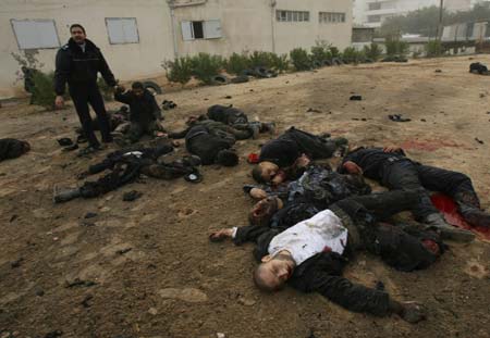 Bodies of Palestinian Hamas policemen are scattered on the ground following an Israeli air strike in Gaza City on Dec. 27, 2008. [Stringer/Xinhua]