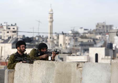 Israeli soldiers take position during scuffles with Palestinian stone-throwers at Qalandiya checkpoint near the West Bank city of Ramallah December 27, 2008. 