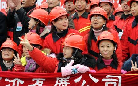 Workers cheer for the damming of the Jinsha River in the construction of the Xiangjiaba Hydropower Station which is the third largest of its kind in China.(Xinhua photo)