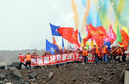 Workers waving flags and banners cheer for the blocking of the Jinsha River at Xiangjiaba, bordering Shuifu County of Yunnan province and Yibin County of Sichuan province, southwest China December 28, 2008. [Xinhua]
