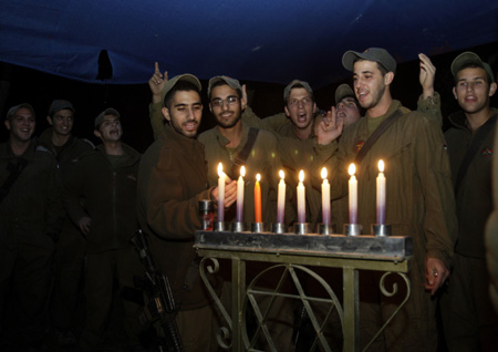 Israeli soldiers light candles for the Jewish holiday of Hanukkah near Kibbutz Mefalsim, just outside the northern Gaza Strip December 28, 2008.