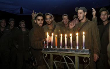 Israeli soldiers light candles for the Jewish holiday of Hanukkah near Kibbutz Mefalsim, just outside the northern Gaza Strip December 28, 2008.