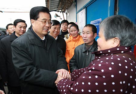 Chinese President Hu Jintao (L Front) shakes hands with a woman as he visits residents of the Xingfu Community in Dujiangyan City, southwest China's Sichuan Province, Dec. 28, 2008. President Hu Jintao visited quake-hit Sichuan Province on Dec. 27-29, showing concern for survivors and inspecting reconstruction work. [Ju Peng/Xinhua]