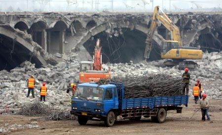 Earth-moving excavators, bulldozers and trucks are busy with the backout project of scraping down the new Lugou Bridge, which is parallel to the adjacent historical Lugou Bridge (Marco Polo Bridge), at the suburb of Beijing, Dec. 28, 2008.[Wu Changqing/Xinhua] 