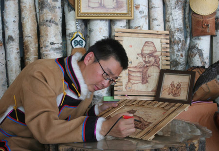 Oroqen handicraftsman He Lei made birch bark painting in Oroqen ethnic autonomous county in north China's Inner Mongolia Autonomous Region, Dec. 26, 2008. 