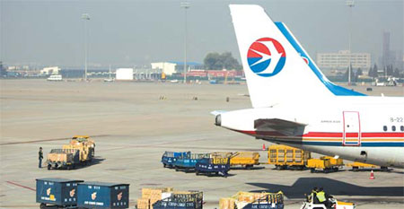 Airport personnel load a China Eastern Airlines passenger jet at a Beijing airport. [Bloomberg News]