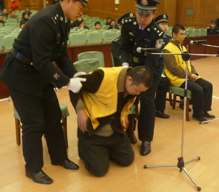 Geng Jinping, a suspect charged with producing and selling poisonous food in the tainted milk scandal, kneels before the court in Shijiazhuang, Hebei Province, December 30, 2008, begging for victims' forgiveness. [Xinhua] 