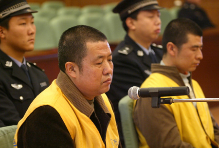 Geng Jinping (front L) and Geng Jinzhu (R), suspects charged with producing and selling poisonous food in the tainted milk scandal, listen during their trial at the court in Shijiazhuang, Hebei Province, December 30, 2008. [Xinhua] 