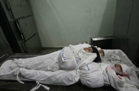 The bodies of three of the five Palestinian siblings lie in the Jabalia refugee camp, Gaza Strip, on Dec. 29, 2008. The five girls from the Baalusha family were killed in an Israeli air raid that targeted a mosque near their home in Jabalia, medics said. [Xinhua]