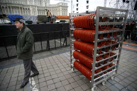 A man stands next to a sausage looped around a rack in Bucharest during a Guinness World Record event for the world's longest sausage Dec. 27, 2008. 