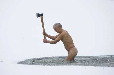 A member of the 'Optimalist' heath club hacks a hole into the ice covering a canal near the village of Viazynka, some 40 km (25 miles) northwest of Minsk Dec. 28, 2008. 