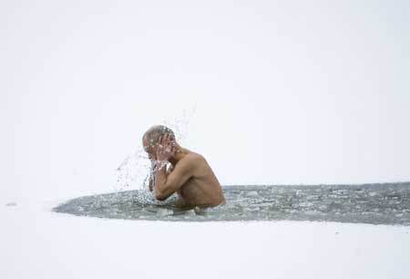 A member of the 'Optimalist' heath club takes a dip in the icy water of a canal near the village of Viazynka, some 40 km (25 miles) northwest of Minsk Dec. 28, 2008. [Xinhua/Reuters]