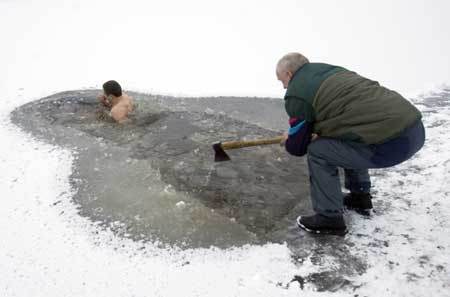 A member of the 'Optimalist' heath club takes a dip in the icy water of a canal near the village of Viazynka, some 40 km (25 miles) northwest of Minsk Dec. 28, 2008. 