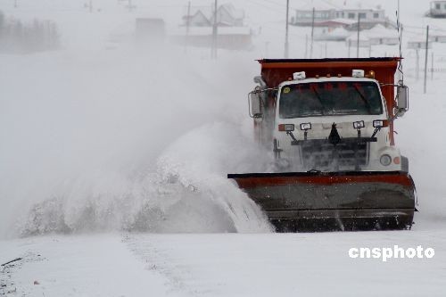 A vehicle sweeps the snow in Hami, Xinjiang Uygur Autonomous Region, on December 27, 2008. Heavy snow hit the region in the past days. 