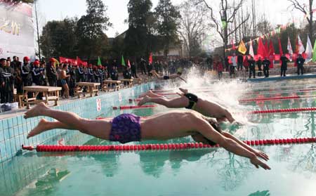Winter swim competitors leap off into the pool, as some 400 swimmers take part in the New Year's Day Winter Swimming Gala match for two days, to mark the national day of Winter Swim, in Caohu City, east China's Anhui Province, Jan. 1, 2009. [Xinhua]