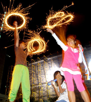 Two children emblaze the fireworks to celebrate the New Year in Jakarta, Indonesia, on Jan. 1, 2009. Lots of local residents came out of home in the wee hours of Jan. 1 to celebrate the new year with fireworks and bugles. [Xinhua]