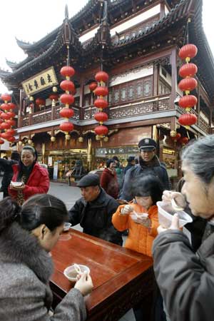 Citizens take free 'Laba Porridge' outside a time-honored pharmacy in Shanghai, China, Jan. 3, 2009. 