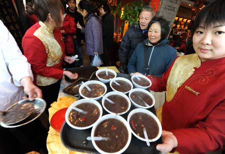 Waitresses prepare bowls of hot porridge for local residents at Gongdelin Vegetarian Restaurant in Beijing, capital of China, on Jan. 3, 3008. 