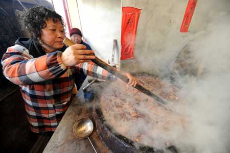 An employee makes Laba porridge at Pilu Temple in Nanjing, capital of east China's Jiangsu Province, on Jan. 3, 2009.