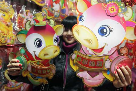 A girl shows New Year decorations in the shape of ox at a wholesale market in Beijing, capital of China, Jan. 3, 2009. As the Chinese lunar New Year approaches, Spring Festival decorations are becoming popular. The Chinese lunar New Year will start from Jan. 26 this year. 