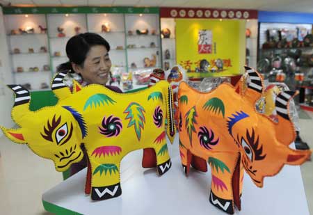 A woman buys New Year decorations shaped in ox at a shopping mall in Binzhou, east China's Shandong Province, Jan. 3, 2009. 